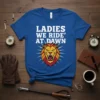 Ladies We Ride' At Dawn t-shirt with white bold text and a roaring lion graphic on a blue shirt