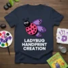 Ladybug Handprint Creation t-shirt with a cute cartoon ladybug and bold white text for kids' art projects