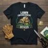Lawn Enforcement Officer t-shirt design featuring a yellow riding mower graphic with laurel wreath and banner text