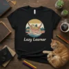 Lazy Learner t-shirt design with a sloth reading a book in a hammock, stacked books, and a sunset graphic