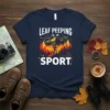 LEAF PEEPING is a SPORT t-shirt with a hiker silhouette against a mountain and fall foliage background