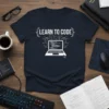 Learn To Code text with a laptop graphic and circuit board design on a navy blue t-shirt