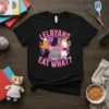 Lelbyans Eat What? text with cartoon cats cooking on a black t-shirt, LGBTQIA pride design