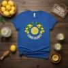 Blue t-shirt with "Lemon Delights" text in a circle around a lemon slice graphic, surrounded by lemons and leaves