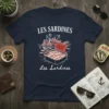 Navy t-shirt with "Les Sardines" text above a graphic of a fishing boat and an open sardine can, also labeled