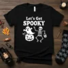 Black t-shirt with white text "Let's Get SPOOKY" and cartoon ghost and skeleton graphics for Halloween