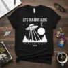 Black t-shirt with "Let's Talk About Aliens" text and a white UFO abduction graphic with planets and stars