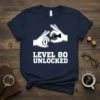 Level 80 Unlocked t-shirt design with hands forming '8' and '0', and a bowtie. Features bold white text