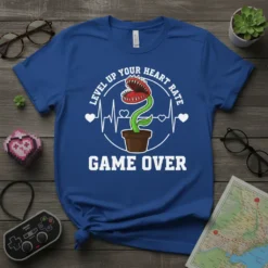 Blue t-shirt with "Level Up Your Heart Rate Game Over" text and a carnivorous plant graphic, featuring a heartbeat line