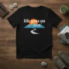 Life Goes On text with mountain, sunset, and road graphic on black t-shirt
