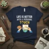 T-shirt with white text "LIFE IS BETTER WITH A PERSONAL TOUCH" and yellow heart graphic. Design shows hands painting a