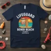 LIFEGUARD BONDI BEACH SYDNEY AUSTRALIA text with lifeguard tower and surfboard graphic on a navy t-shirt