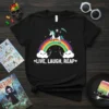 Live Laugh Reap t-shirt design with a grim reaper riding a unicorn over a rainbow and clouds