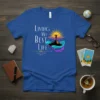 Living My Best Life affirmation t-shirt with a silhouette of a person on a mountain at sunrise, surrounded by colorful