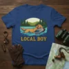 Local Boy t-shirt design featuring a golden retriever swimming with a duck in its mouth, with trees and mountains in
