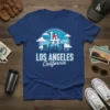 Blue t-shirt featuring a circular graphic of the Los Angeles skyline, clouds, and the text "LA" and "LOS ANGELES California"