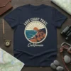 Lost Coast Trail California t-shirt design featuring hikers on a coastal cliff at sunset, with rope border detail