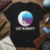 Lost in Gravity t-shirt design with an astronaut swinging on the moon against a retro sunset sky