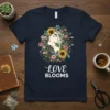 Navy t-shirt with "Love Blooms" text and a woman's profile surrounded by colorful flowers and sunflowers
