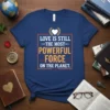 T-shirt with the quote "Love Is Still The Most Powerful Force On The Planet" in bold yellow and white typography