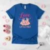 Blue t-shirt with "Love LITTLE FEET" text and baby feet on clouds graphic, pink and orange design