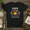 Love Planted Here text with floral heart graphic on a black t-shirt, perfect for gardeners and plant lovers