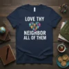 Navy t-shirt with white text "LOVE THY NEIGHBOR ALL OF THEM" and a heart made of diverse people icons