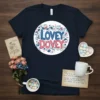 Lovey Dovey text in blue and pink, surrounded by floral and heart motifs, printed on a navy t-shirt