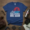 MAKE AMERICA BIKE AGAIN T-Shirt with cyclist silhouette, gears, and red-white-blue sunset graphic