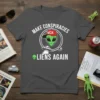 Make Conspiracies Aliens Again text with green alien wearing MCA hat and UFO graphic on a dark grey t-shirt