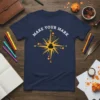 Navy blue t-shirt with "Make Your Mark" quote above a golden compass design featuring an inkwell and quill
