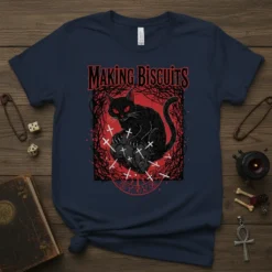 Gothic t-shirt design with the text "MAKING BISCUITS" above a black cat sitting on a pile of crosses, surrounded by