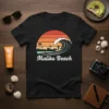 Malibu Beach retro surf t-shirt design with a crashing wave, surfers, palm trees, and a sunset skyline
