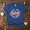 Blue t-shirt with "Mama" text, crown, peace sign, and pink flower inside a laurel wreath design