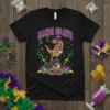 Black t-shirt with "Mardi Grawr" text and a T-Rex wearing a hat, standing on a tire with Mardi Gras masks