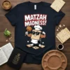Matzah Madness! text with a cartoon matzah character flexing muscles on a navy t-shirt