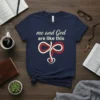 Navy t-shirt with "me and God are like this" text and a heart symbol representing the bond