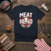 Meat Head T-Shirt design with text, bull skull graphic, crossed cleavers, and flames. Perfect for BBQ lovers