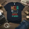 T-shirt with "MEDIA MOST EFFECTIVE DEVIL IN AMERICA" text and a devil graphic holding media devices
