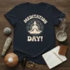 MEDITATION DAY! text with a meditating silhouette surrounded by a mandala design on a navy t-shirt
