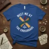 Meet Me At The Crossroads quote on a blue t-shirt with a graphic of crossed paths, a compass, and a
