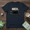 MEH. text above a black cat lying down with a bored expression on a navy t-shirt