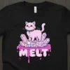 MELT t-shirt design with a pink pastel goth cat sitting on purple and pink crystals, with dripping letters