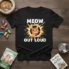 Black t-shirt with "MEOW OUT LOUD" text and a cartoon orange cat bursting from a yellow sunburst graphic