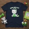 Navy t-shirt with "MEOW AND PLAY ALL DAY" text above a cute cartoon cat in a green dress and green