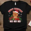 Meowy Christmas Ho Ho Ho text with a cute cat wearing a Santa hat and gifts, on a black t-shirt
