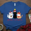 Merry Catmas t-shirt design featuring three cute cats wearing Christmas hats and holding gifts