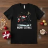 Black cat wearing a Santa hat and scarf hanging Christmas ornaments, text reads Merry Catmas, on a t-shirt