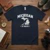 Navy blue t-shirt featuring "Michigan Up North" text with a silhouette of Michigan and mountain graphics