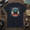Midnight Feline T-Shirt with a black cat walking in front of a retro striped sunset graphic